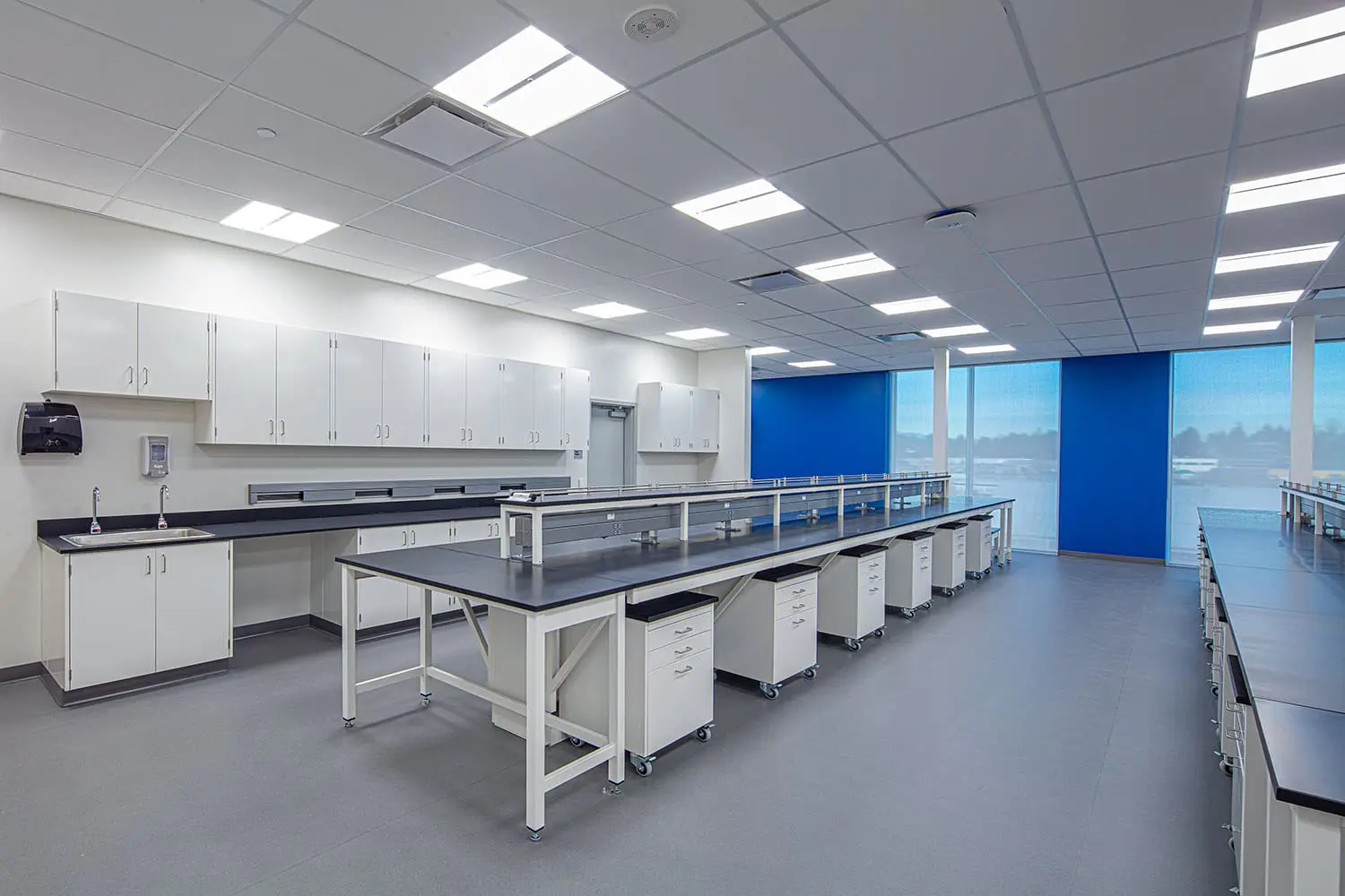 Rows of white laboratory benches with blue accent panels at BCIT Health Sciences Centre