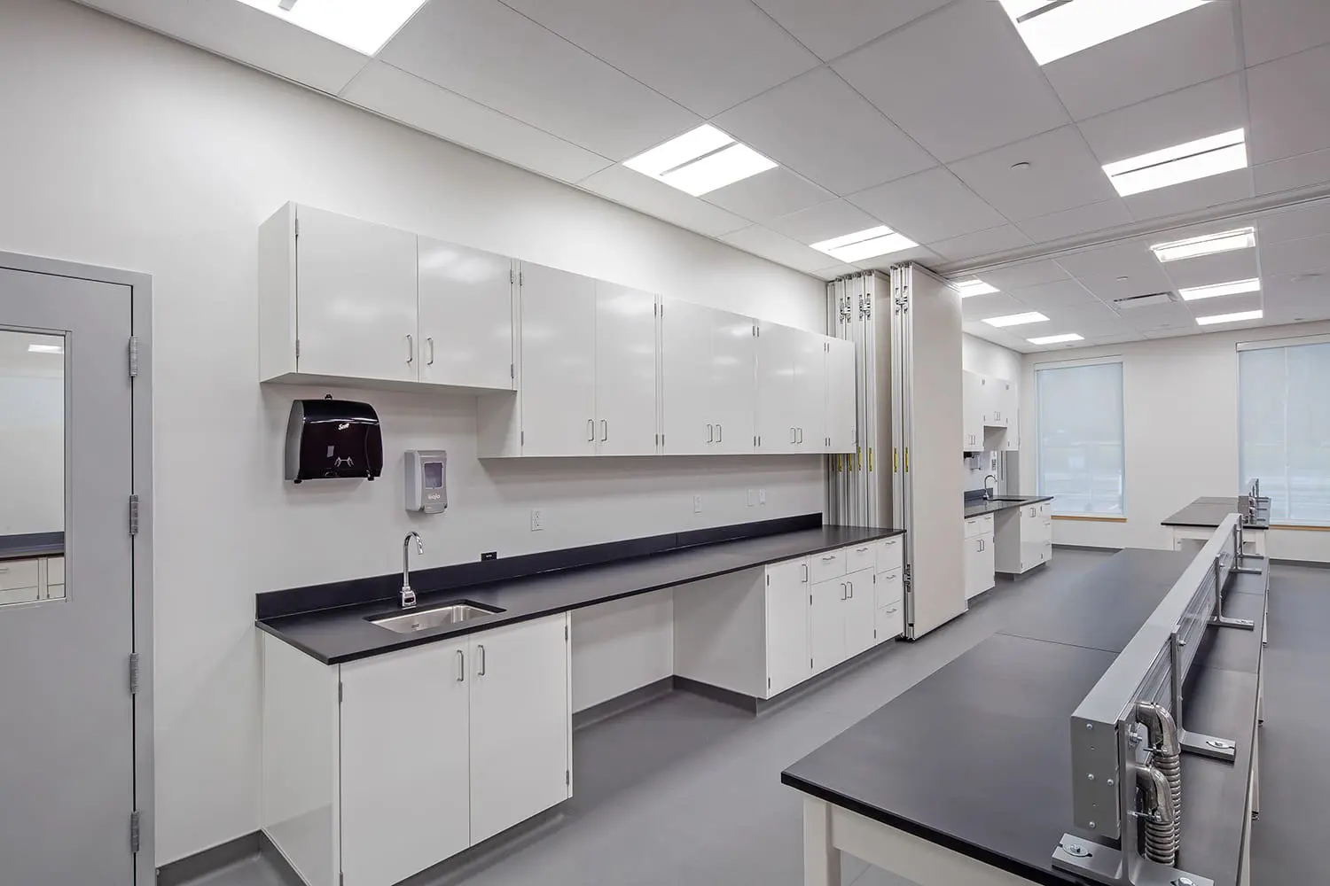 White laboratory casework with black epoxy work surfaces and a sink run at BCIT