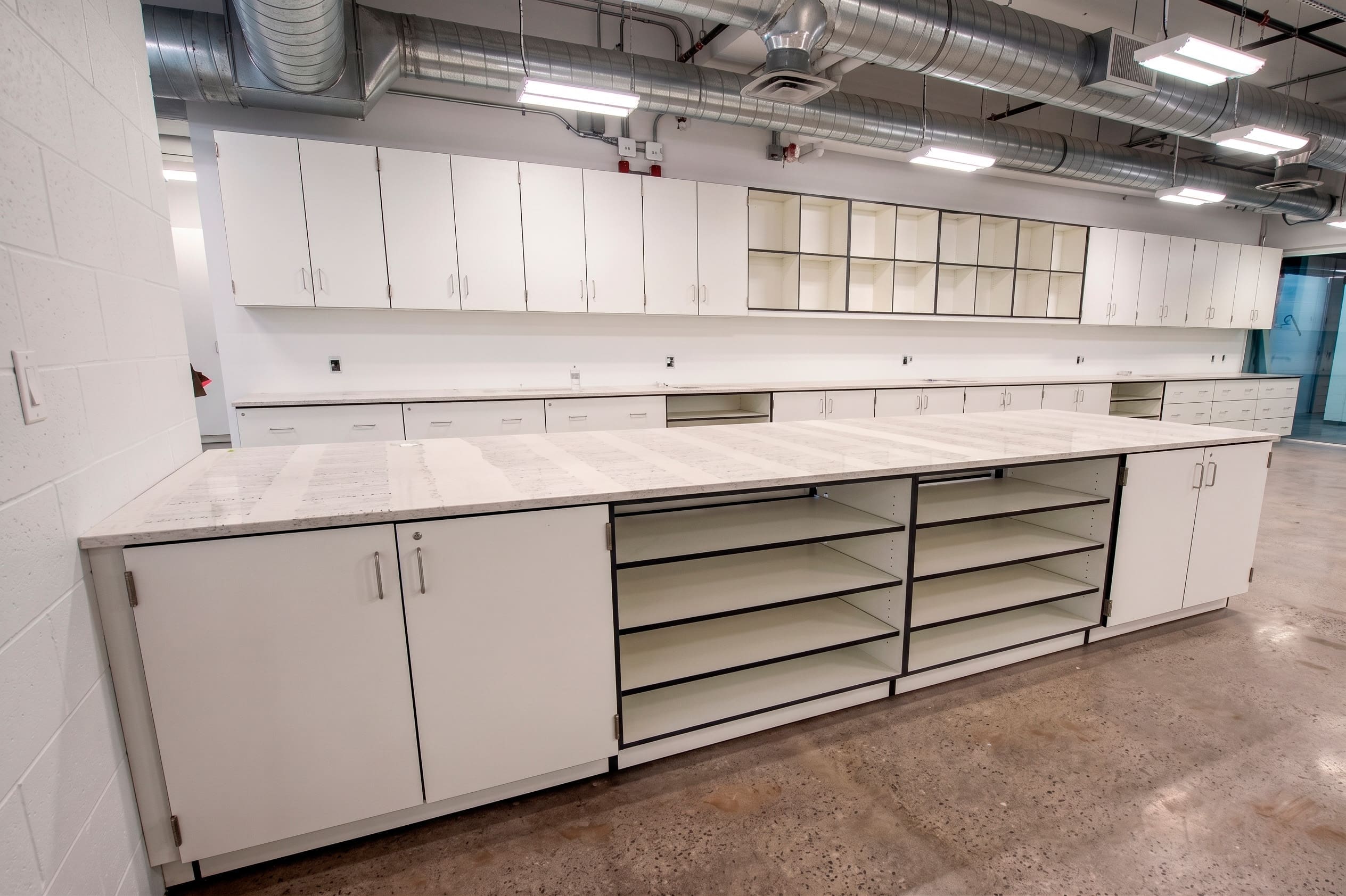 White laboratory casework with open shelving and drawers